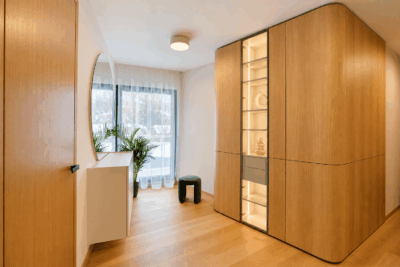 Chodba s dubovou vstavanou skriňou s presklenou osvetlenou vitrínou, okrúhlym zrkadlom a komodou, Luxusná vila 368 m² Praha
